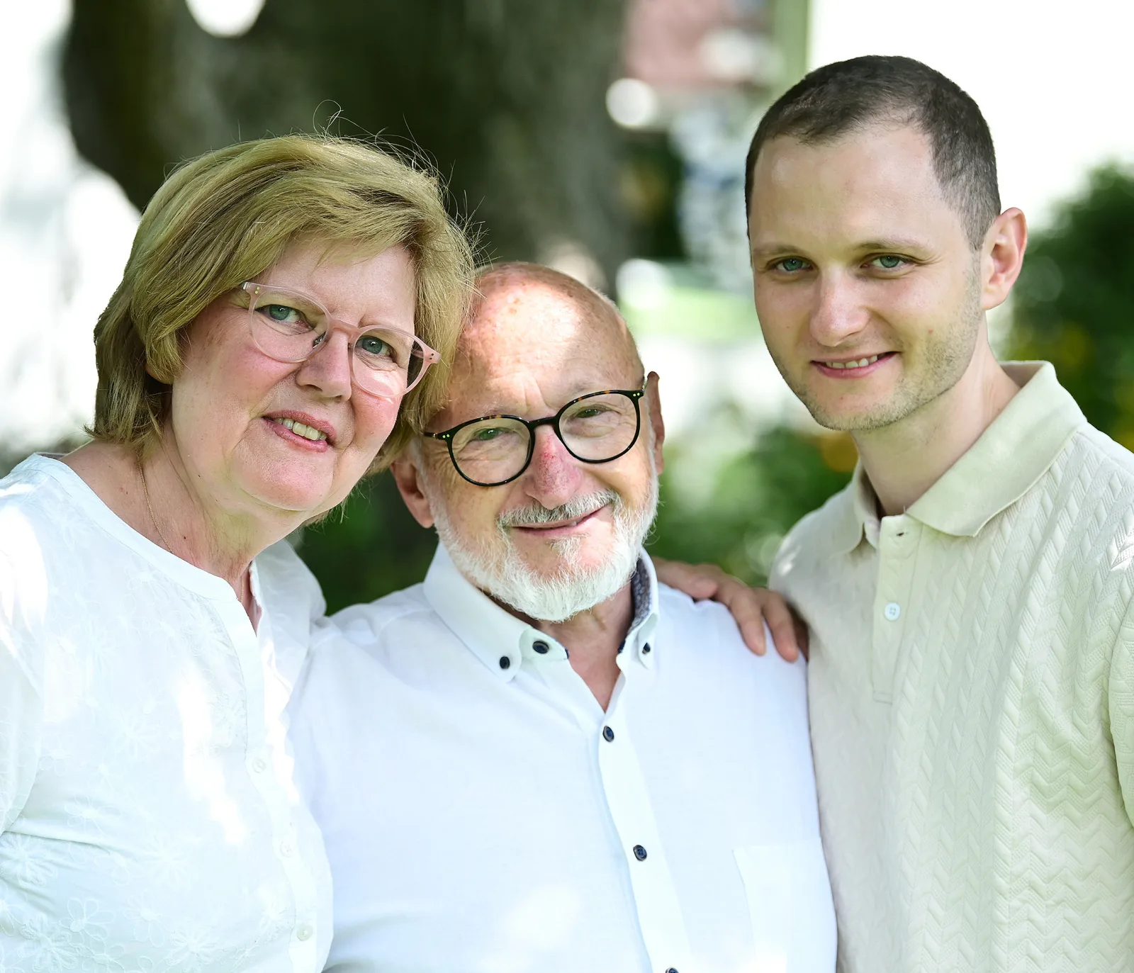 Regina Fichter, Arturo Fichter-Seefeld und Dr. Lucas Fichter stehen Arm in Arm im Garten